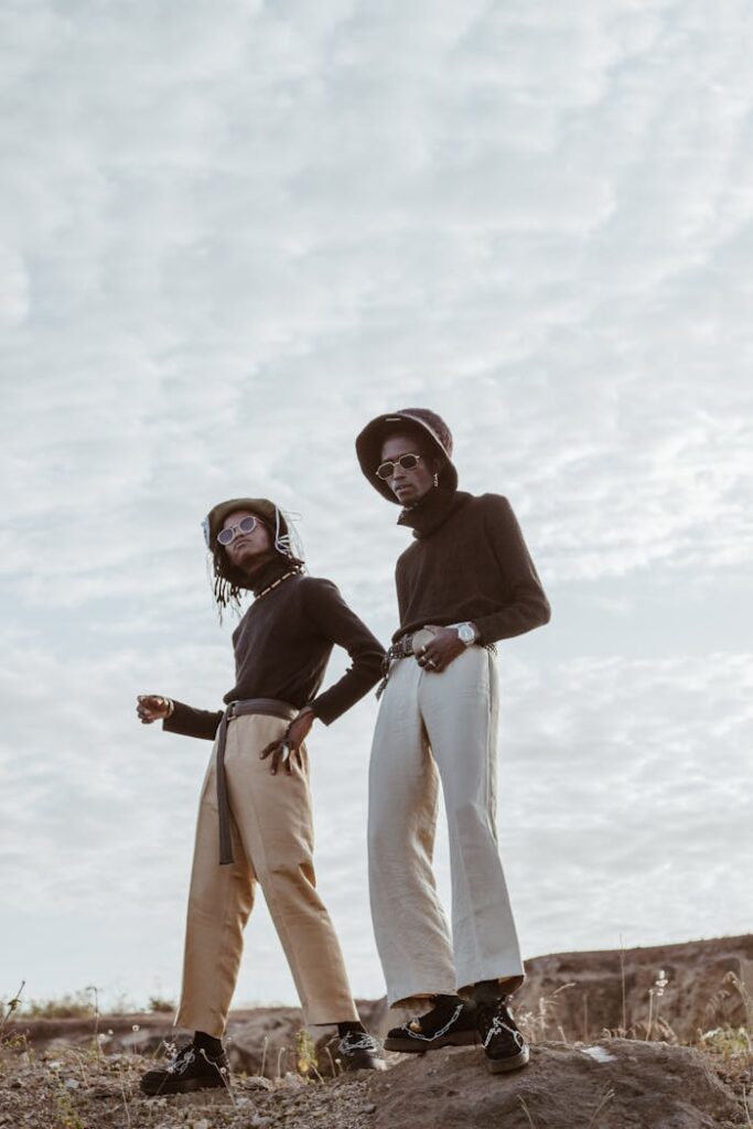 Stylish young black men chilling on rough ground in countryside